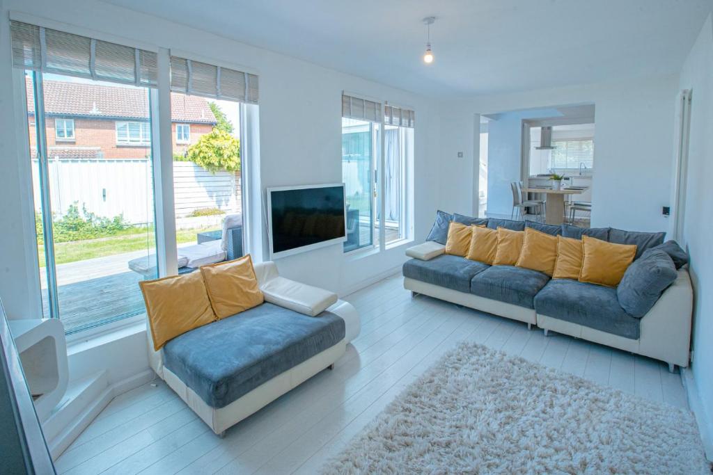 a living room with two couches and a tv at Luxury retreat in Shirley North in Elmers End