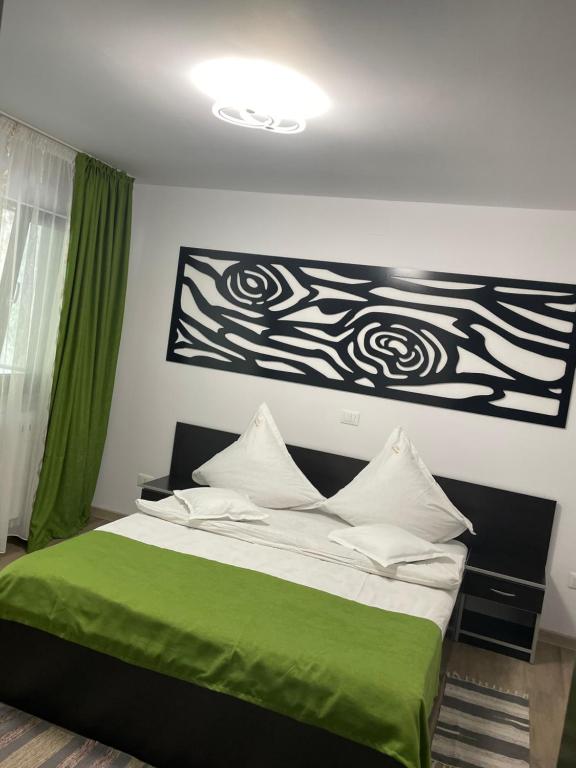 una camera con un letto e una coperta verde di Vila Emage a Moieciu de Sus