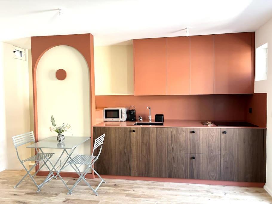 une cuisine avec une table, des chaises et un comptoir dans l'établissement Magnifique studio + balcon au cœur d'Aix, à Aix-en-Provence