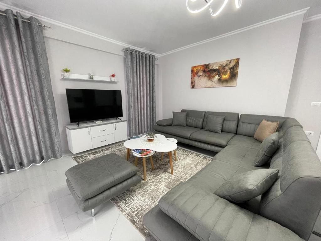 - un salon avec un canapé et une télévision dans l'établissement Luxury Apartment Korca, à Korçë