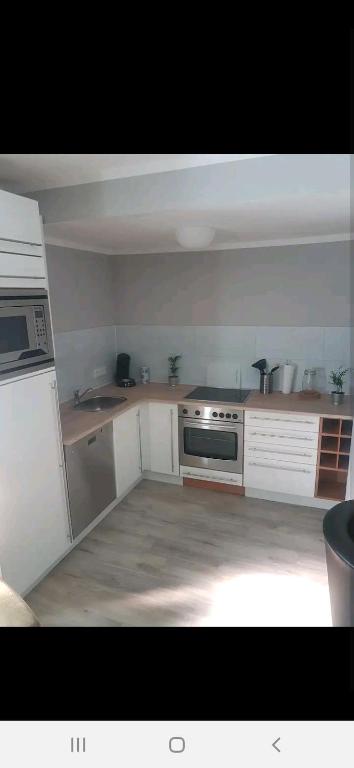 a kitchen with white cabinets and a stove top oven at City Ferienhaus in Neheim in Arnsberg