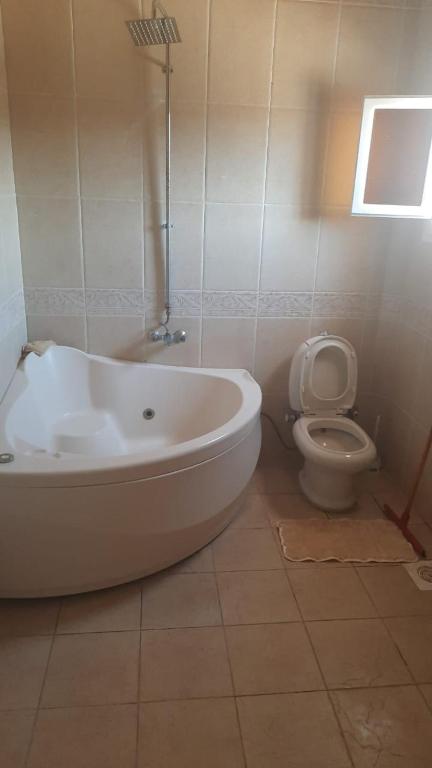 a bathroom with a white tub and a toilet at فيلا مرسي مطروح شاطيء الأبيض in Marsa Matruh