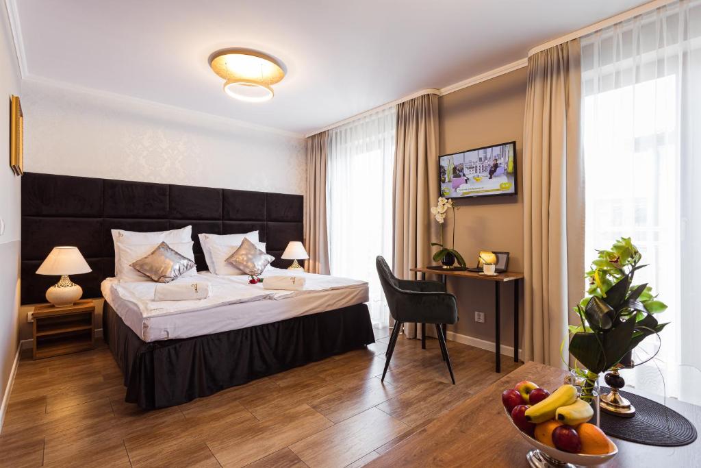 Pokój hotelowy z łóżkiem i stołem z krzesłem w obiekcie Poduszka Willa Arkadia w mieście Mielno