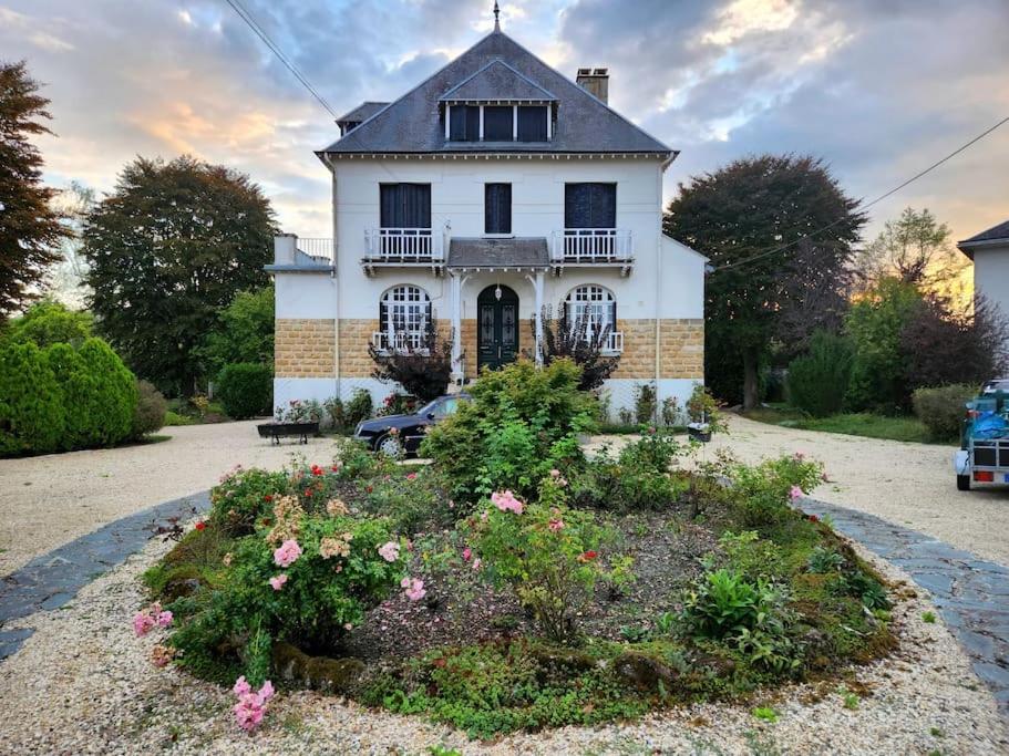 ein Haus mit einem Blumengarten davor in der Unterkunft Maison de maître - Les Marizys in Vouziers
