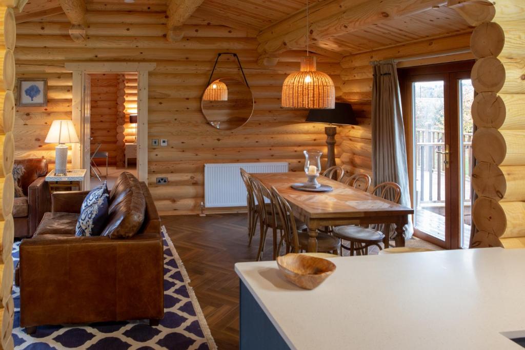 a log cabin living room with a dining room table at Pheasant's Roost in Foxton