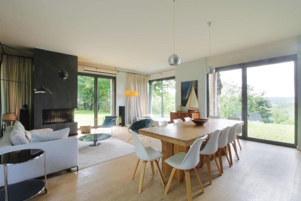 ein Esszimmer und ein Wohnzimmer mit einem Tisch und Stühlen in der Unterkunft Family villa with swimming pool in Aiguebelette-Le-Lac in Aiguebelette-le-Lac