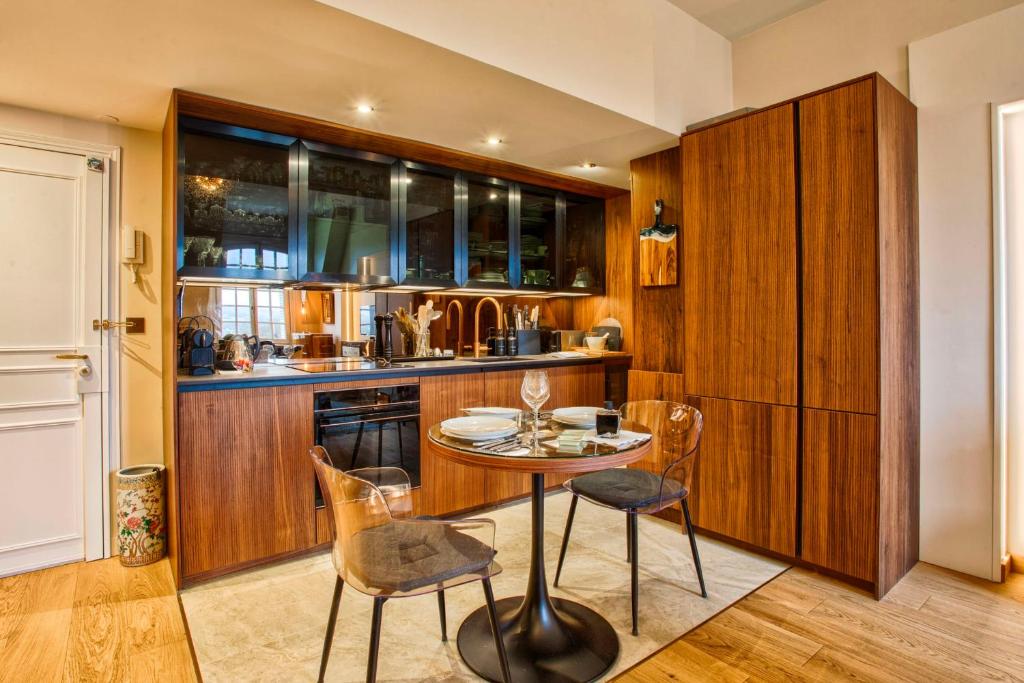 a kitchen with wooden cabinets and a table and chairs at Le Grand Galop - Duplex in Deauville