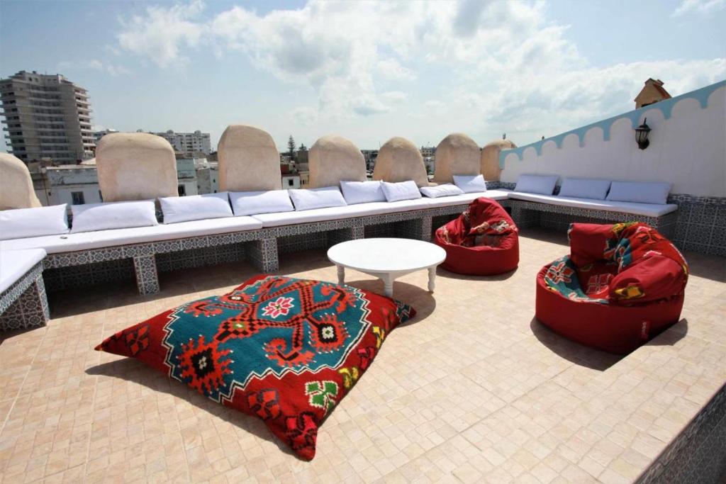a rooftop patio with two bean chairs and a table at Dar Sandra Bizerte in Bizerte