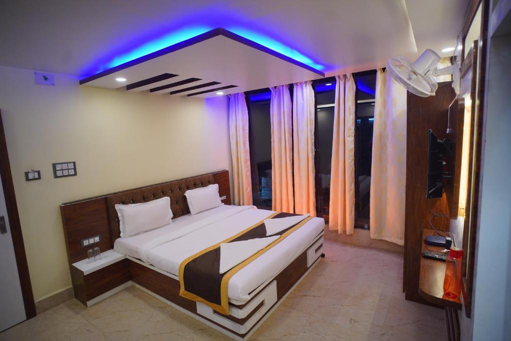 Schlafzimmer mit einem Bett mit blauem Licht in der Unterkunft Hotel Asha Inn in Jasidih