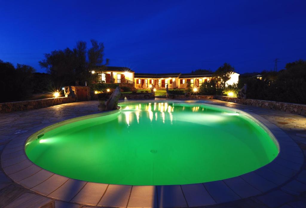 una piscina verde in un cortile di notte di Agriturismo Salmarina ad Abbiadori