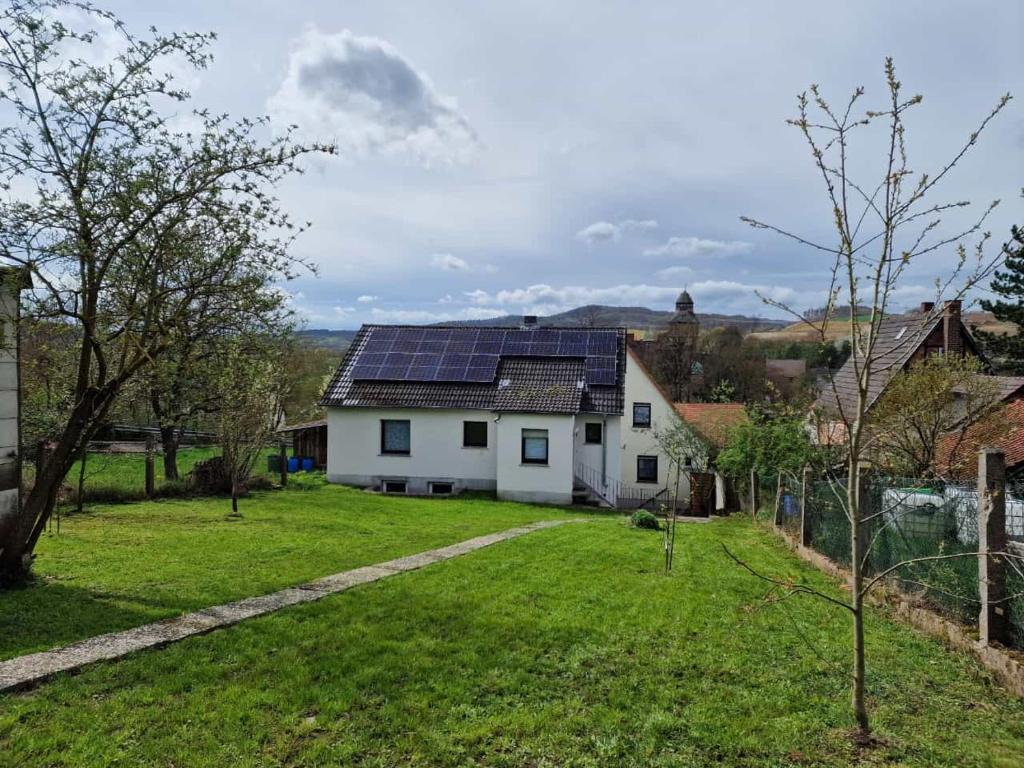 a white house with solar panels on its roof at Ferienhaus Lichtenberg in Herleshausen