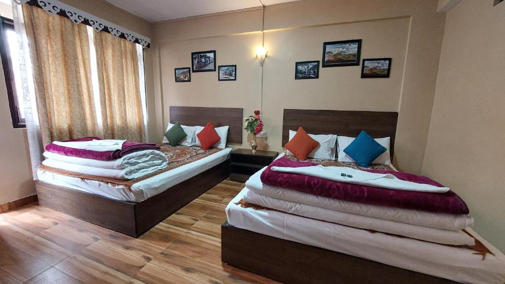 two beds in a room with two at Indivar Homestay in Darjeeling