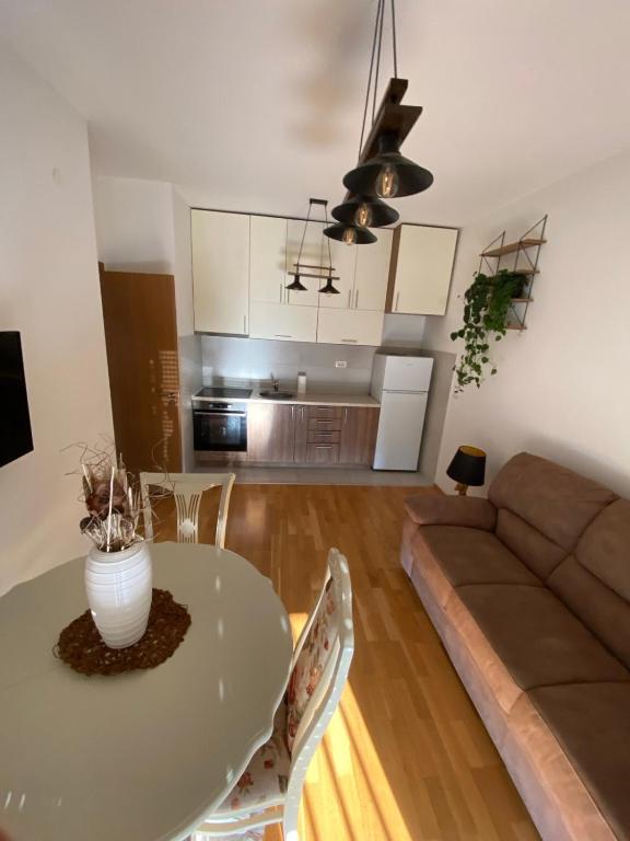 - un salon avec une table et un canapé dans l'établissement Lux Apartment Meecoon, à Podgorica