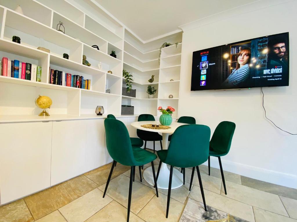 a dining room with a table and green chairs at Luxury 3 Bed Apt in Camden in London