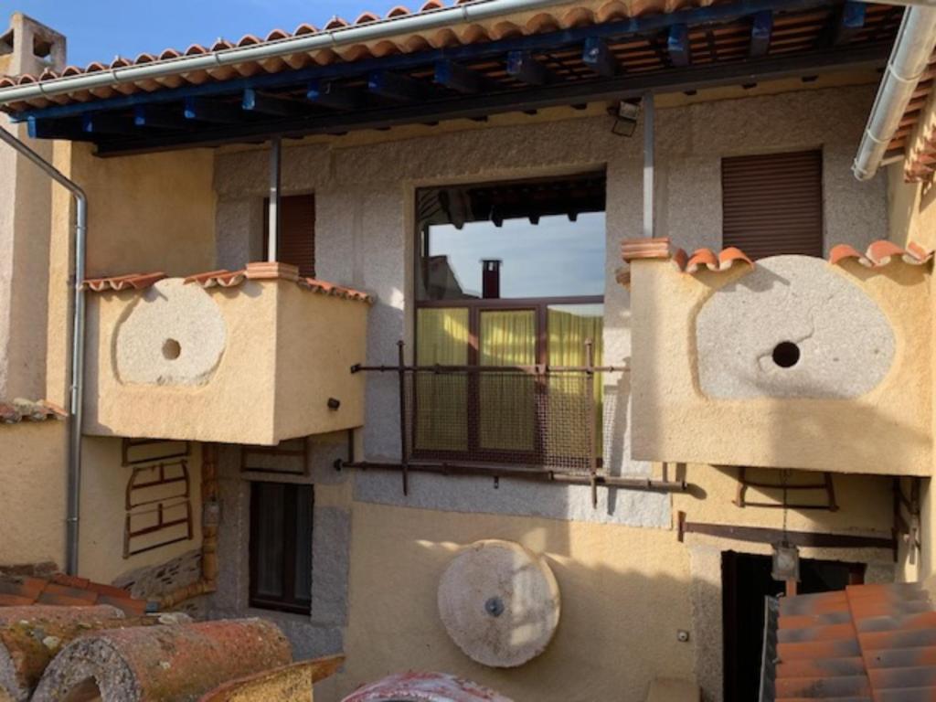 a building with two boxes on the side of it at Casa Rural La Vertedera 3 in Villar de Ciervo