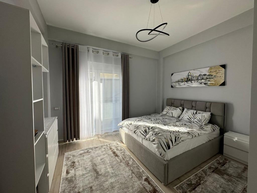 um quarto com uma cama e uma janela em Modern City Suite em Korçë