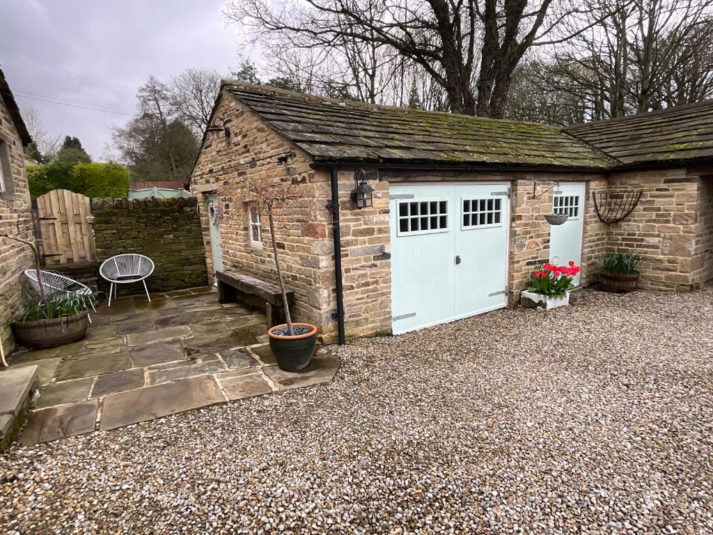 a garage with a white door and a brick building at Badgers Rest with free parking in Apperley Bridge
