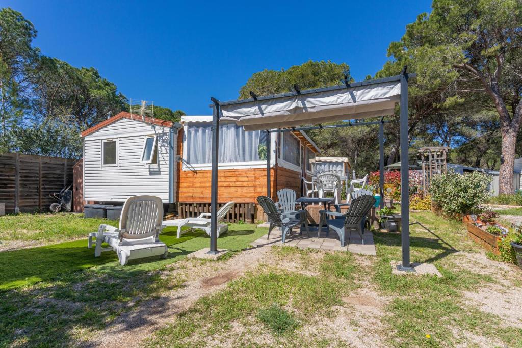 uma pequena casa com um gazebo, uma mesa e cadeiras em Logement camping Oasis em Puget-sur Argens
