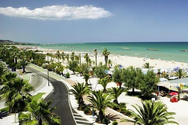 una vista di una spiaggia con palme e l'oceano di GioEl house a San Benedetto del Tronto