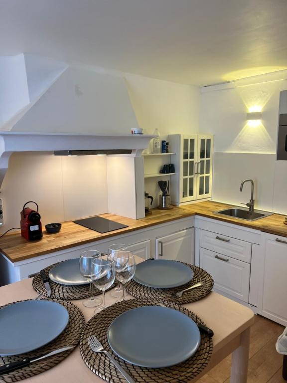 une cuisine avec une table avec des assiettes et des verres à vin dans l'établissement T1Bis Centre Ville tout équipé #8 New, à Toulon
