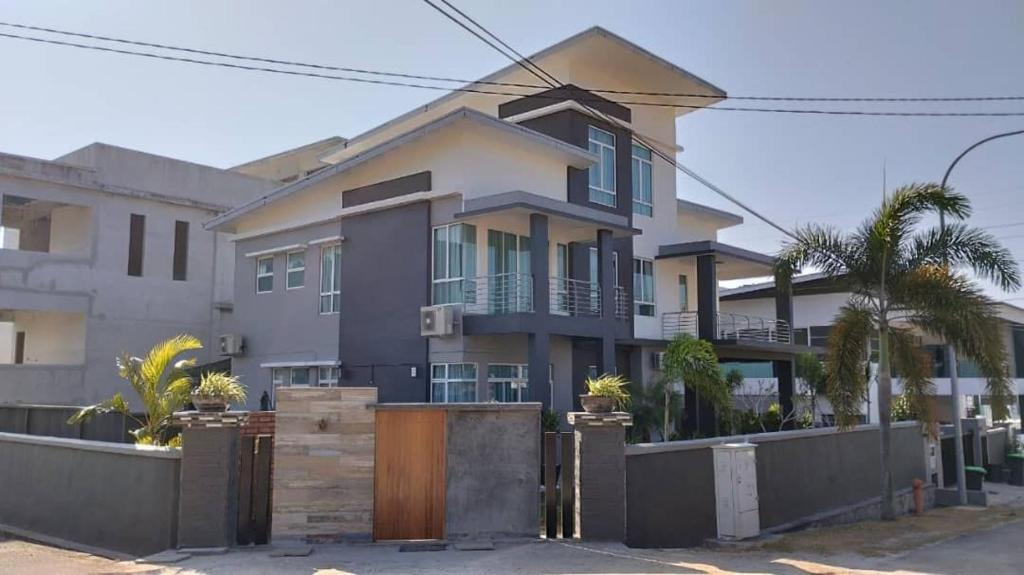 a large house with a fence in front of it at Lodge 16 Private Villa in Kuah