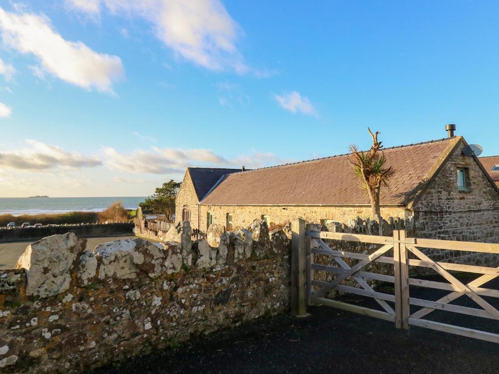 a stone building with a gate and a fence at The Coach House in Haroldston West