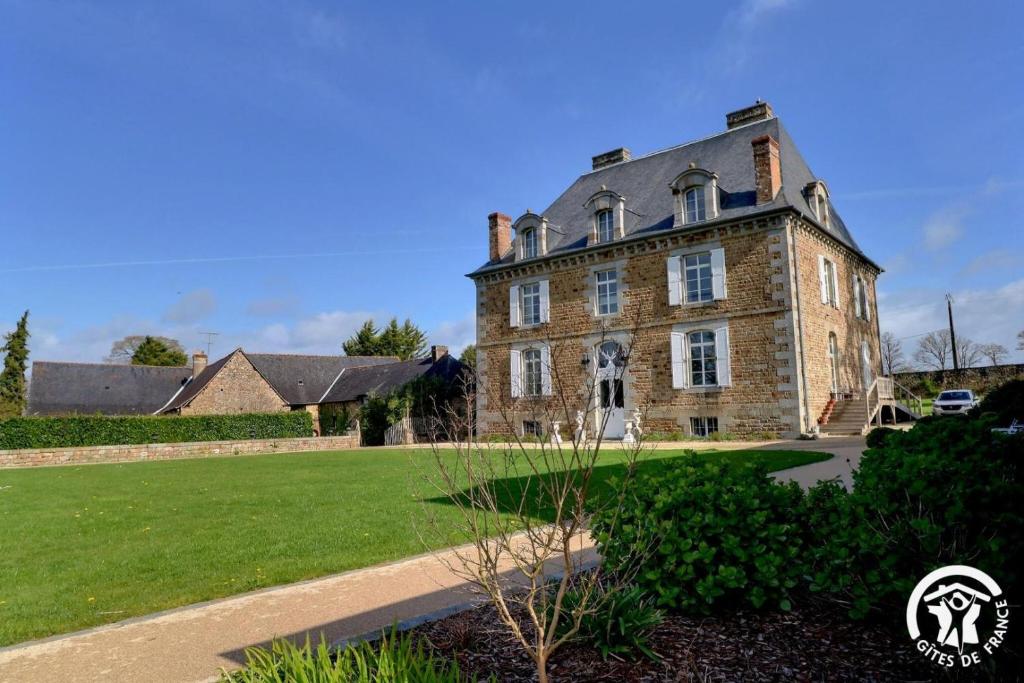 une ancienne maison en pierre avec une grande cour dans l'établissement Chateau de la giraudais, à Mézières-sur-Couesnon