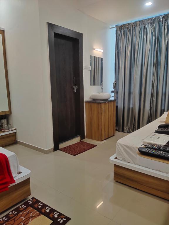 a bedroom with a bed and a bathroom with a sink at Hotel Sai Maa in Shirdi