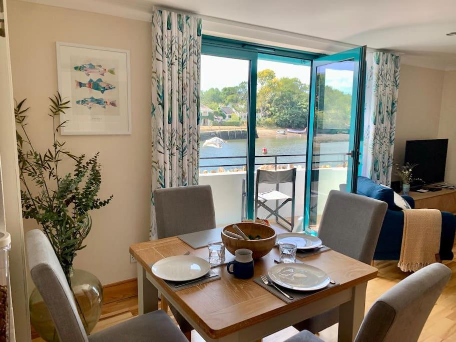 Un comedor con mesa y sillas y una ventana. en Crabshell Quay waterfront living in Kingsbridge, en Kingsbridge