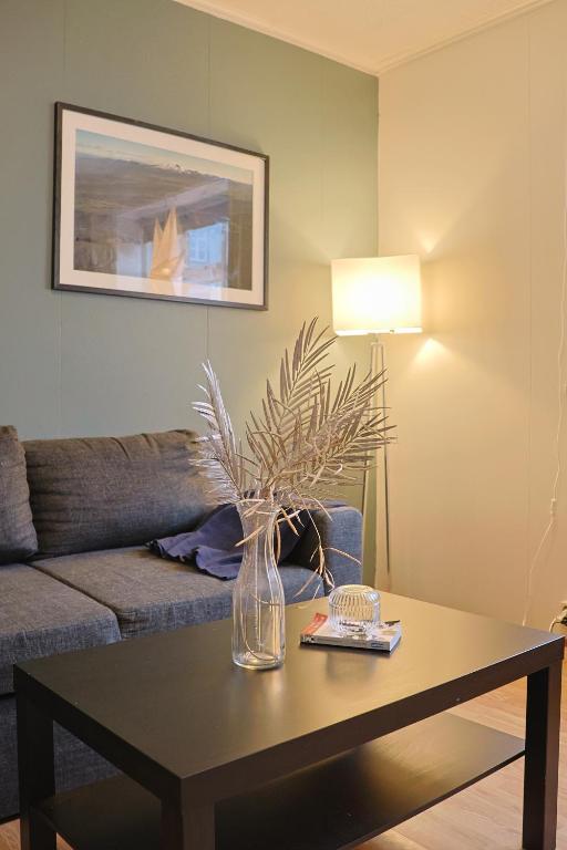 - un salon avec une table et un vase dans l'établissement Lagertha’s apartment,downtown Reykjavik, à Reykjavik