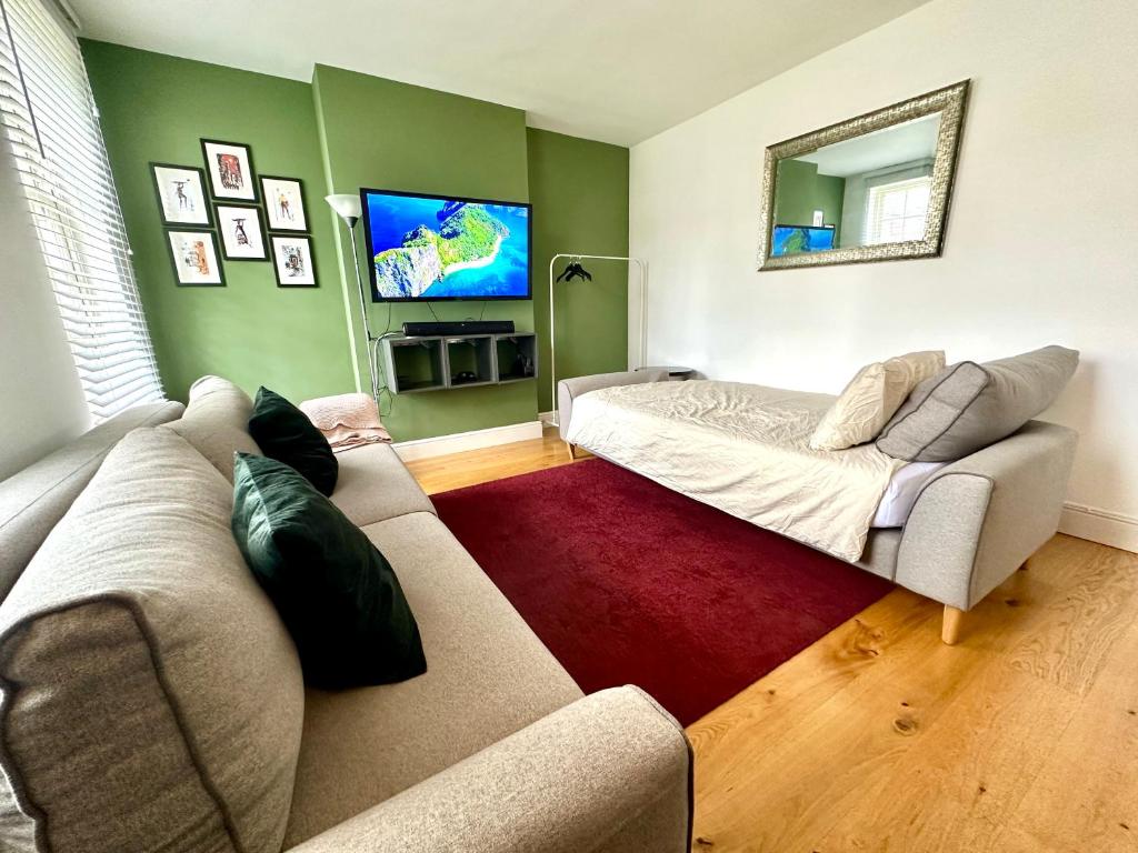 a living room with a couch and a flat screen tv at Colindale Lush Stay 30 mins central London in Colindale