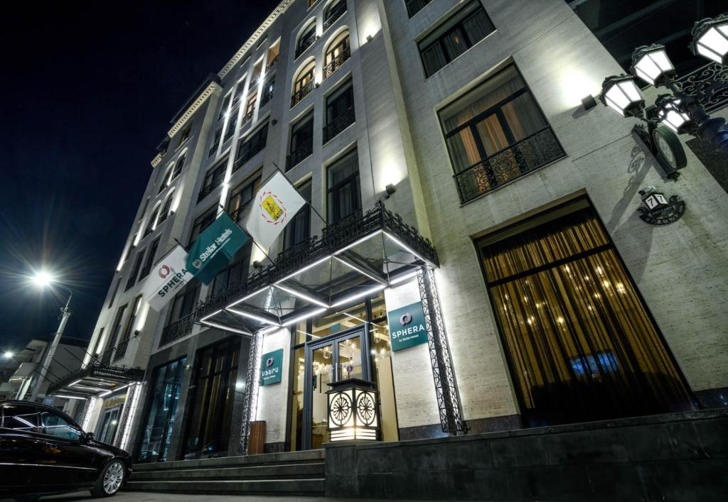 a building with a store on a street at night at Sphera by Stellar Hotels, Yerevan in Yerevan