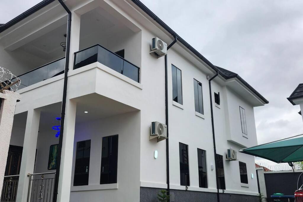 a white building with a balcony on it at MeTime Residence Enugu in Enugu