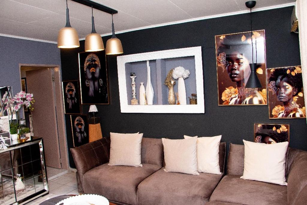 a living room with a couch and pictures on the wall at Villa Raissa 2 in Libreville