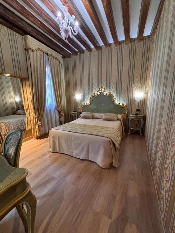 a bedroom with a bed and a chandelier at Hotel al Graspo de Ua in Venice