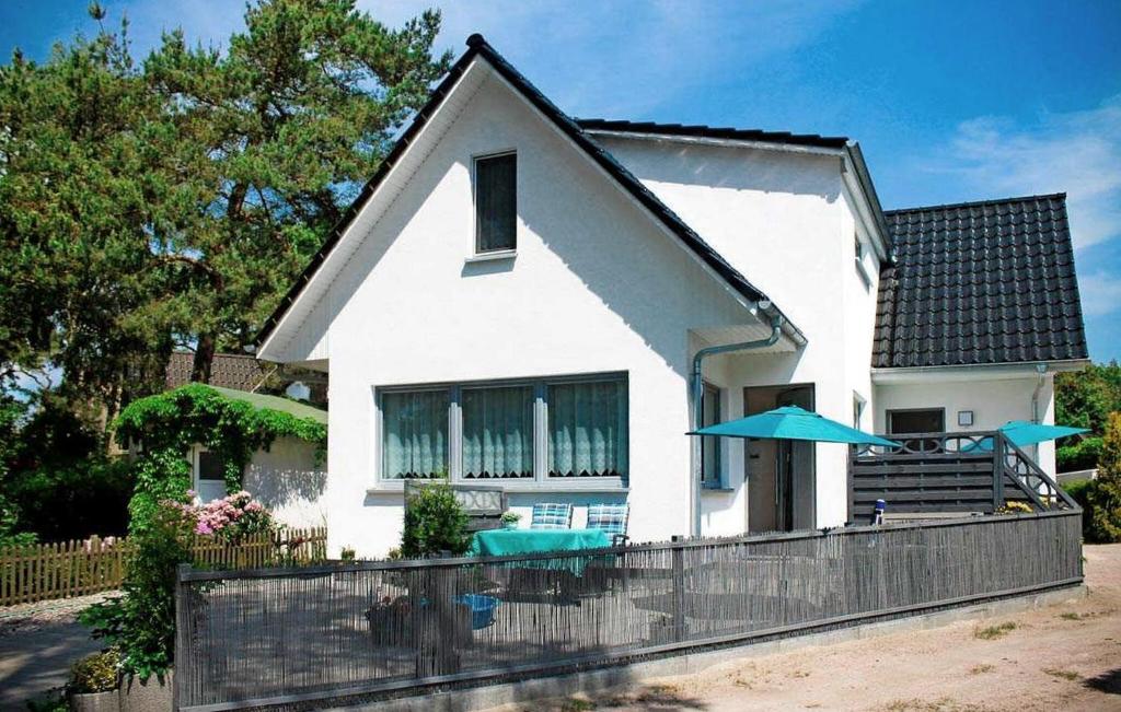 uma casa branca com uma piscina em frente em 1 Bedroom Lovely Apartment In Dierhagen ostseebad em Neuhaus