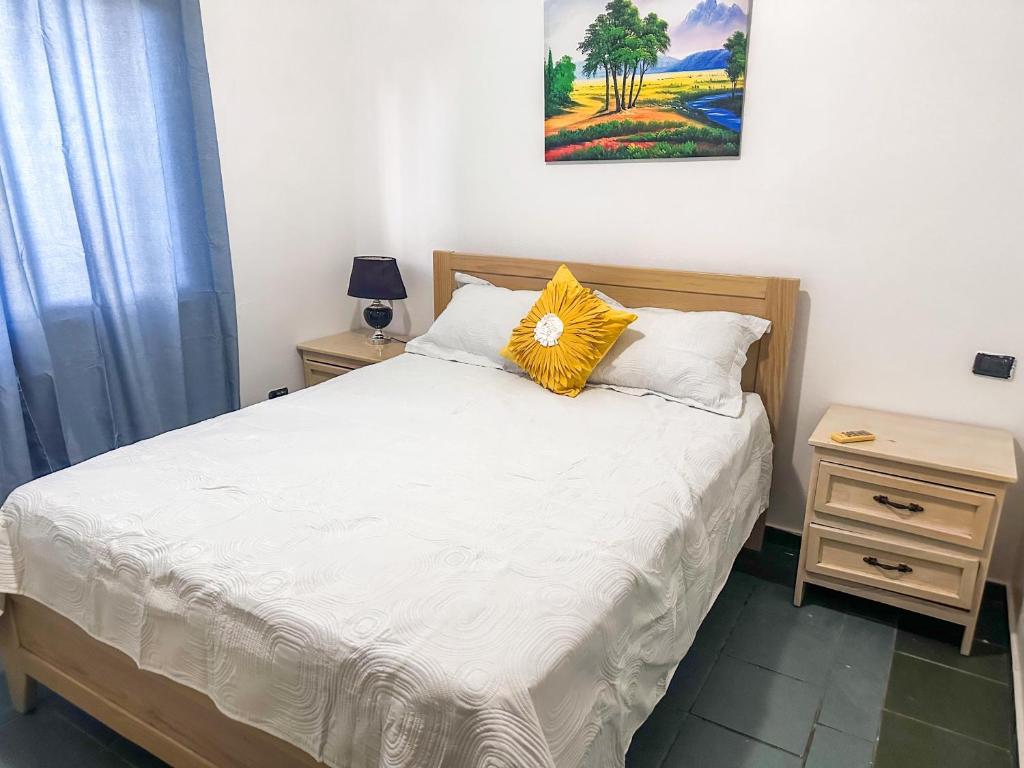 Dormitorio con cama con almohada amarilla en Boca chica Relax en Boca Chica
