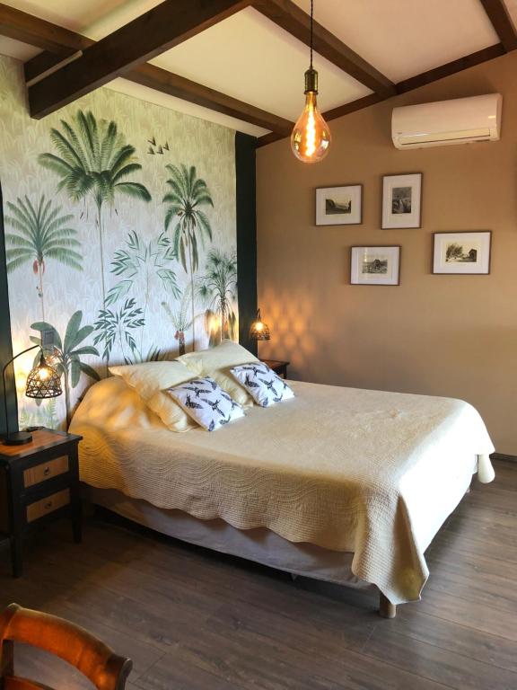 a bedroom with a large bed with a mural of palm trees at La Plantation in Saint-Joseph