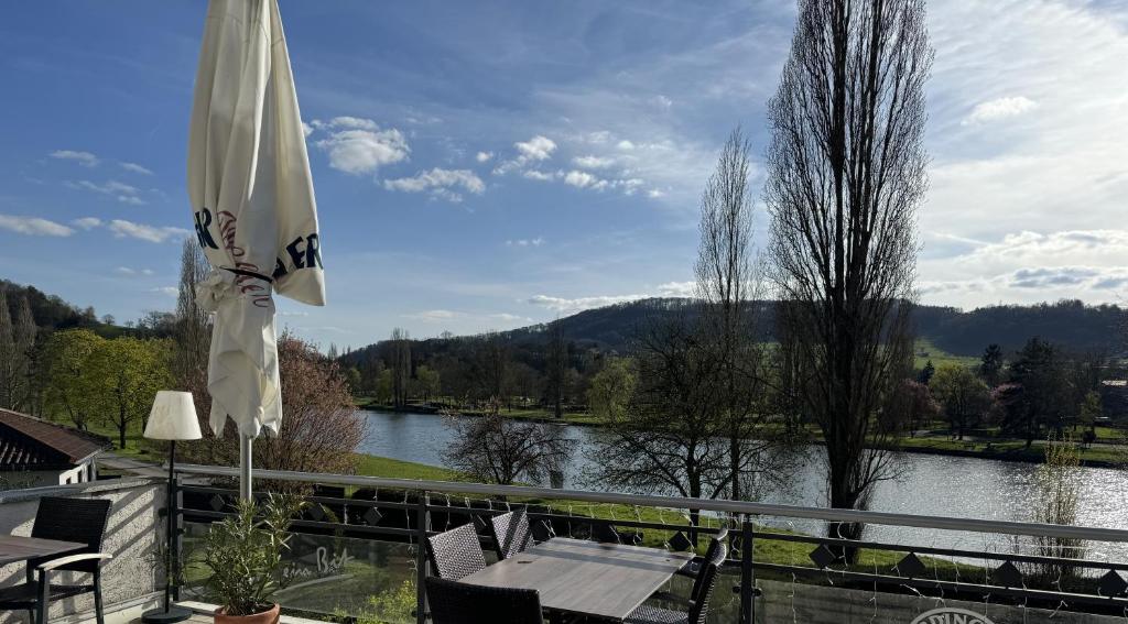 a patio with a view of a river and an umbrella at Landgasthof Ralinger Hof in Ralingen