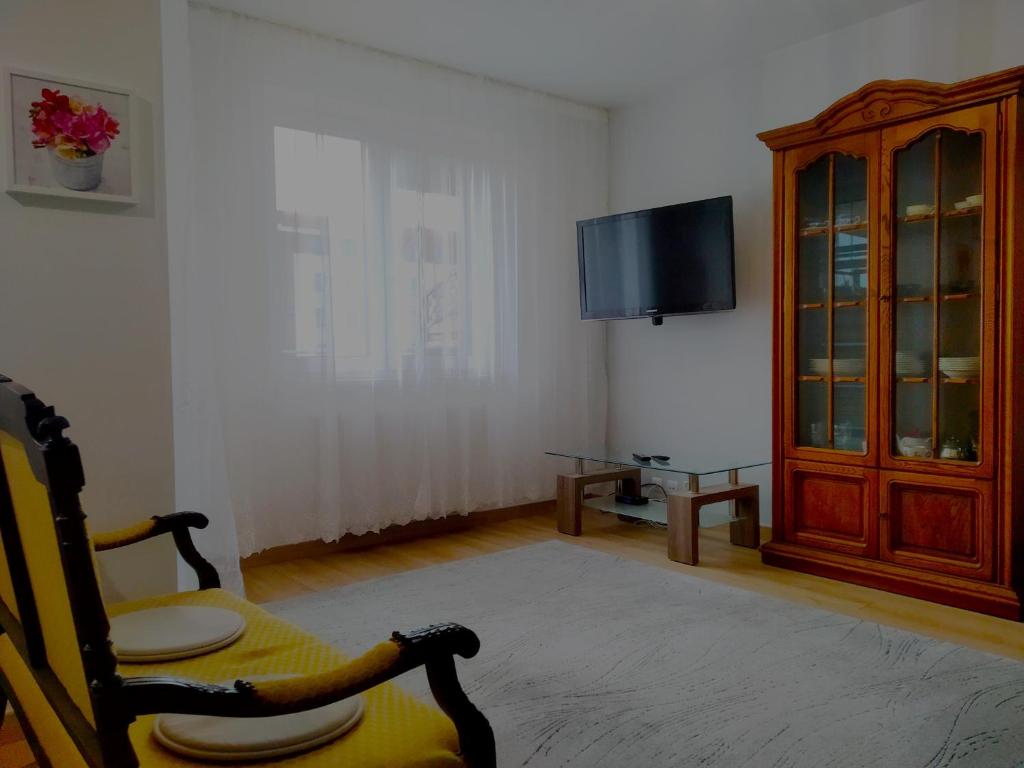 a living room with a tv and a chair at Apartament Białystok in Białystok