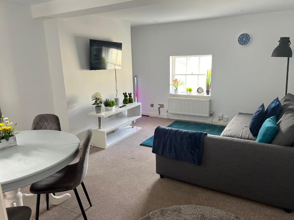 uma sala de estar com um sofá e uma mesa em Russell Square Apartment em Brighton & Hove
