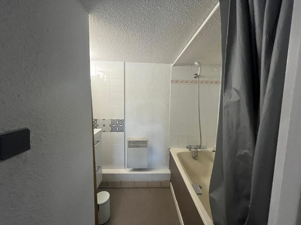 a bathroom with a tub and a toilet and a sink at Le Génépi in Taninges