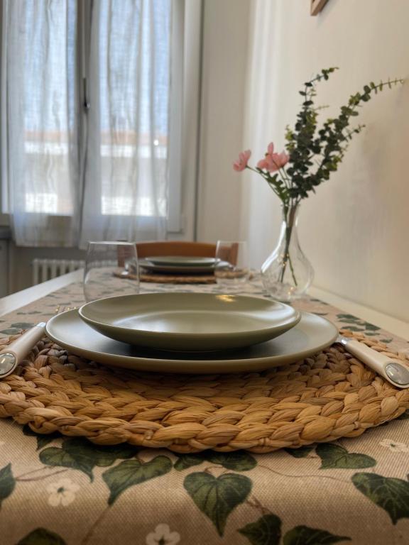 une table avec une assiette et un vase avec des fleurs dans l'établissement Casa Vianello, à Padoue