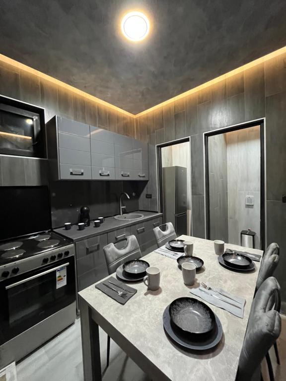 uma cozinha com uma mesa com cadeiras e um fogão em Diamond Hostel em Divčibare