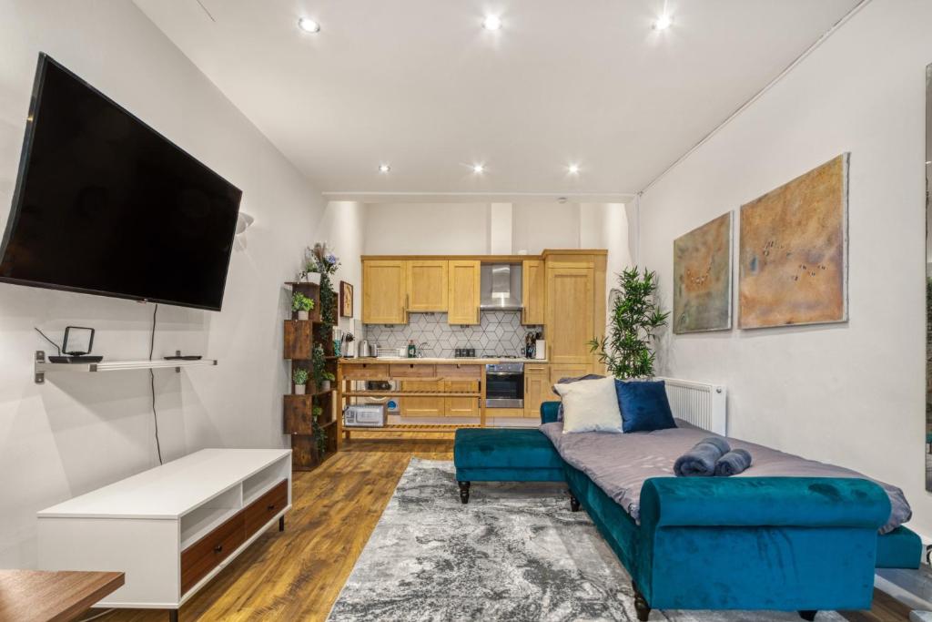 a living room with a couch and a flat screen tv at Vibrant 2-Bed by Bow in London