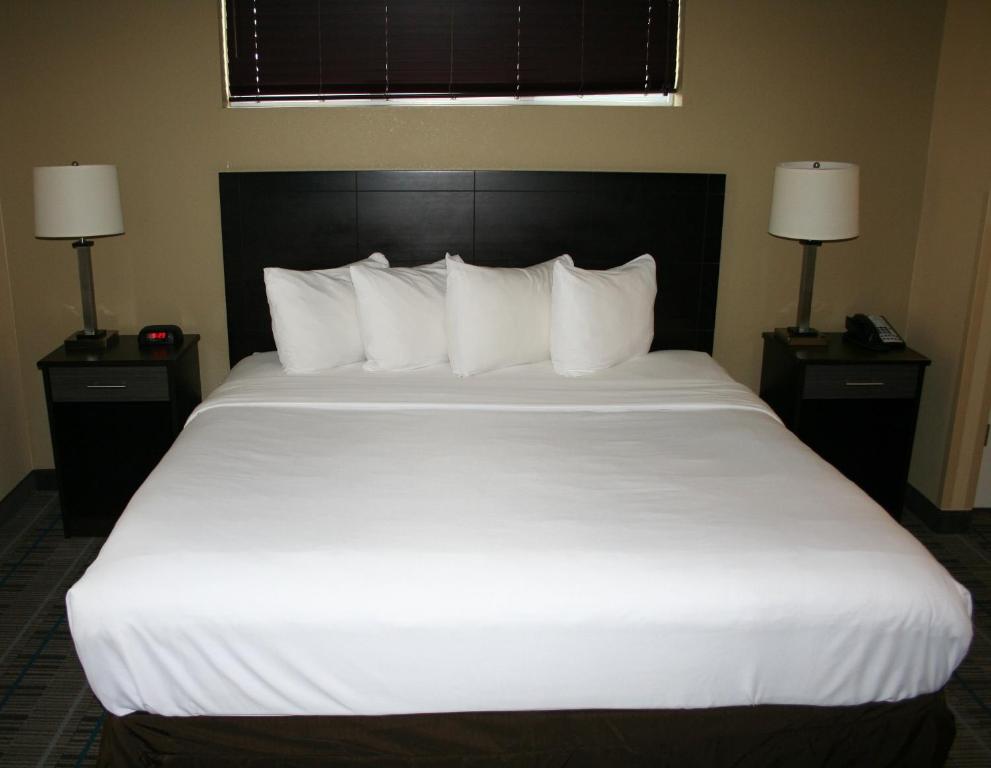 ein großes weißes Bett in einem Hotelzimmer in der Unterkunft MainStay Suites Jacksonville near Camp Lejeune in Jacksonville