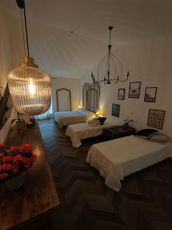 Duży pokój z 2 łóżkami i żyrandolem w obiekcie Garda Relais Antica Romelia w mieście Montichiari