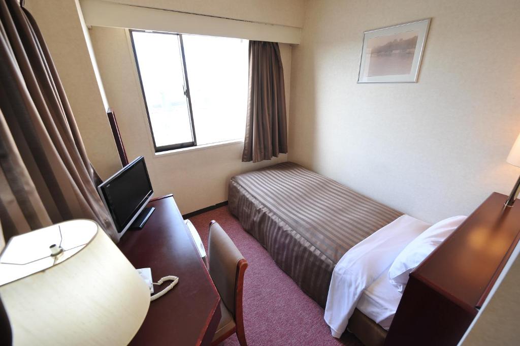 Postel nebo postele na pokoji v ubytování Hotel Crown Hills Naruto