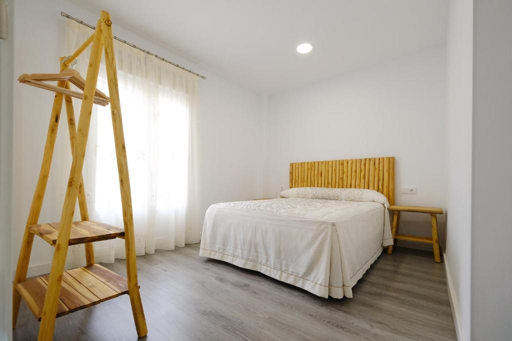 1 dormitorio con cama y escalera de madera en Los Miradores del Arrabal, en Toledo