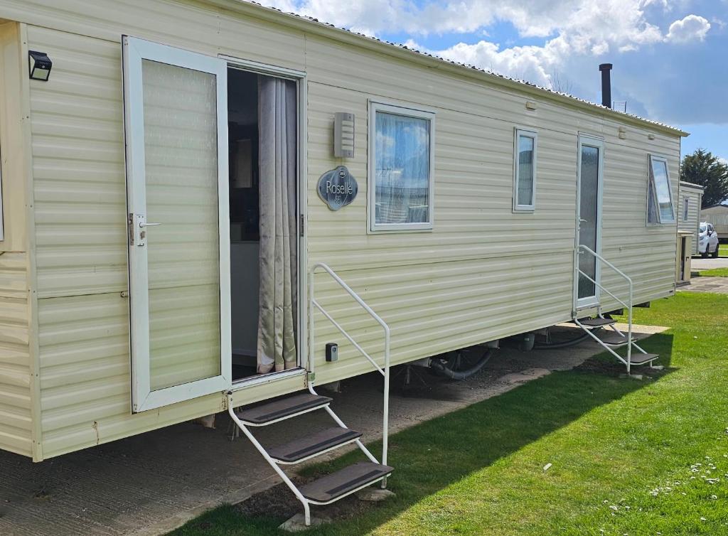 gelber Wohnwagen mit Tür und Veranda in der Unterkunft J.R. Holiday Homes in Clacton-on-Sea